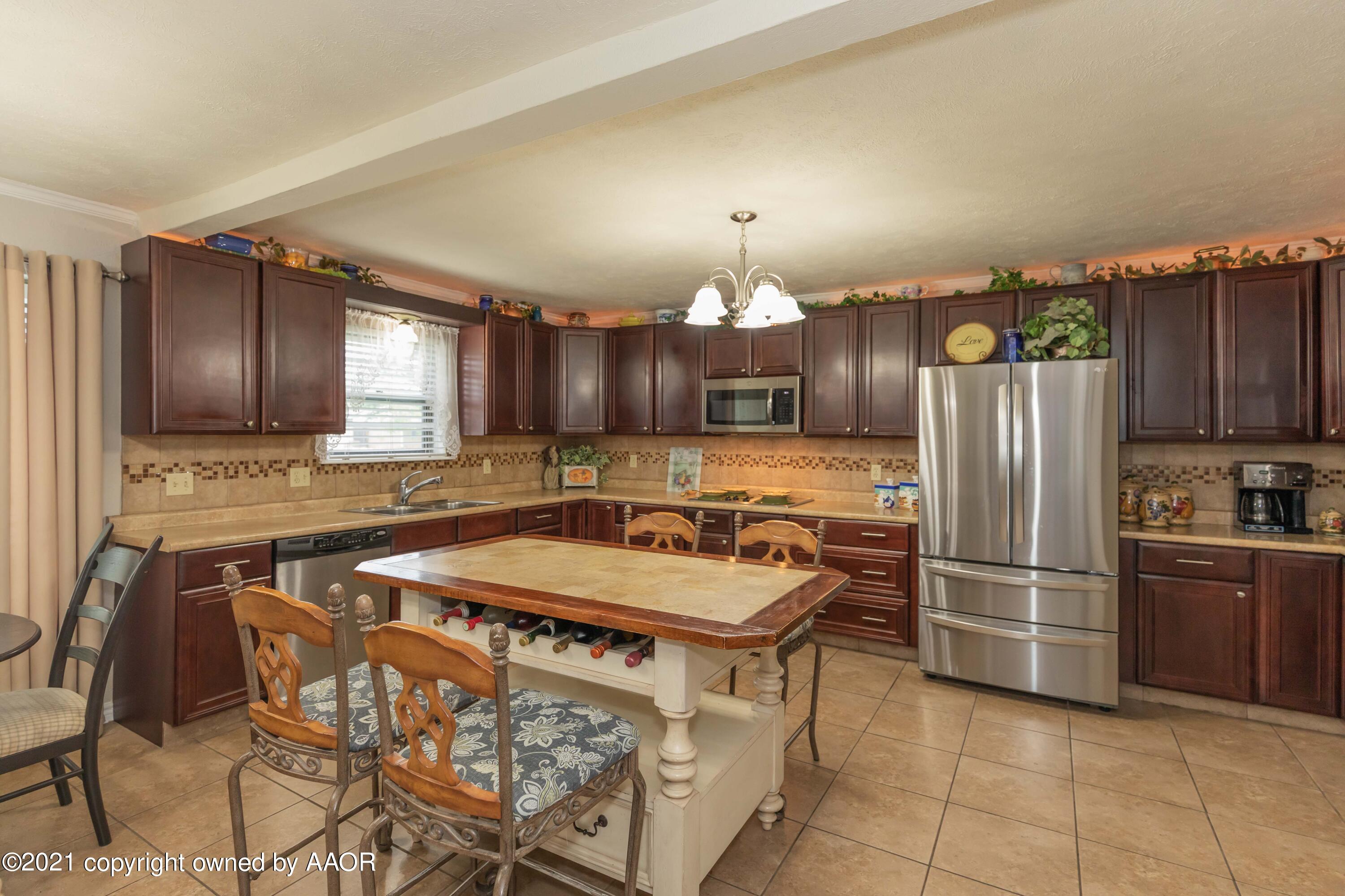 4707 Journey Street Amarillo, TX 79110 - Photo 13 of 65 a kitchen with stainless steel appliances granite countertop a sink refrigerator and cabinets