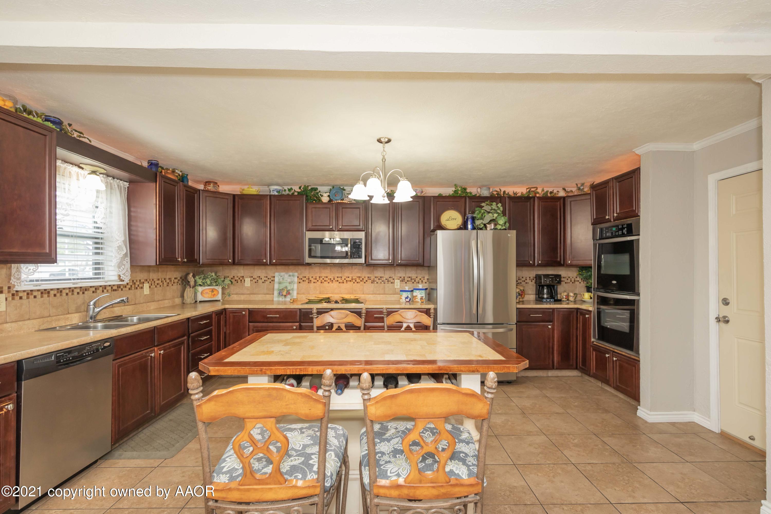 4707 Journey Street Amarillo, TX 79110 - Photo 14 of 65 a kitchen with a stove and a refrigerator