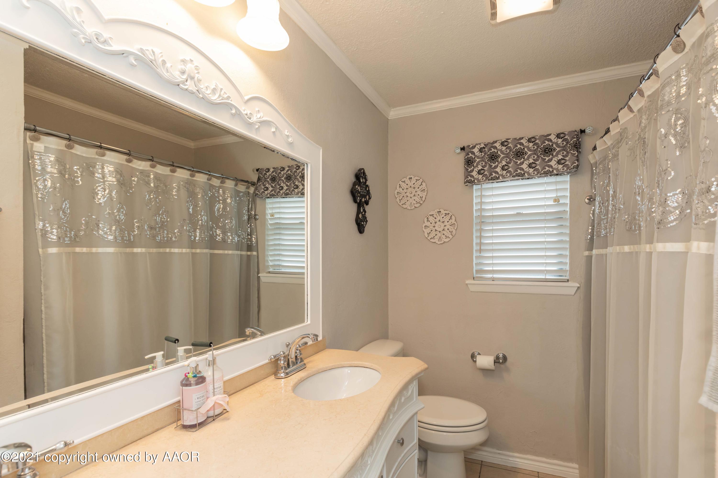 4707 Journey Street Amarillo, TX 79110 - Photo 27 of 65 a bathroom with a granite countertop sink a toilet a mirror and shower