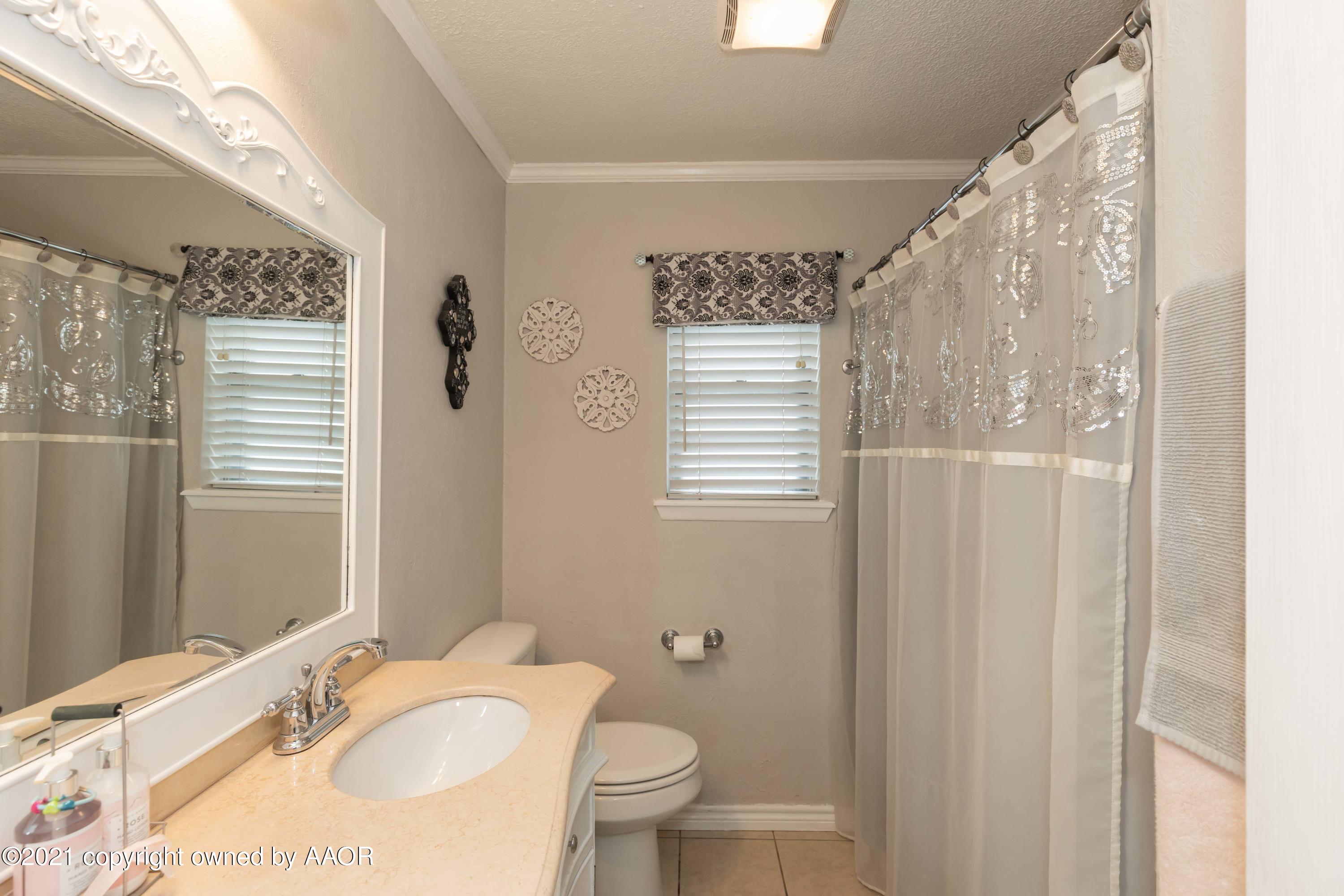 4707 Journey Street Amarillo, TX 79110 - Photo 28 of 65 a bathroom with a granite countertop sink toilet and shower