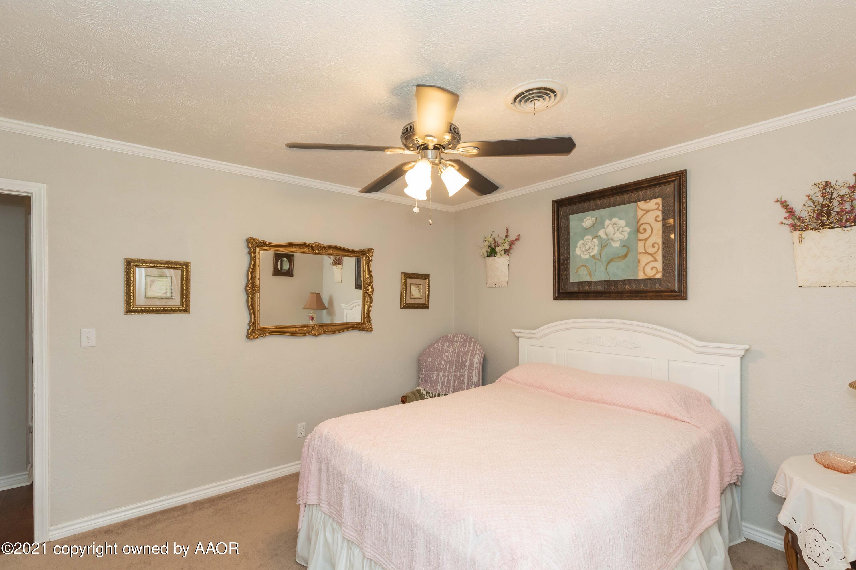 4707 Journey Street Amarillo, TX 79110 - Photo 30 of 65 a bedroom with a large bed and a chandelier
