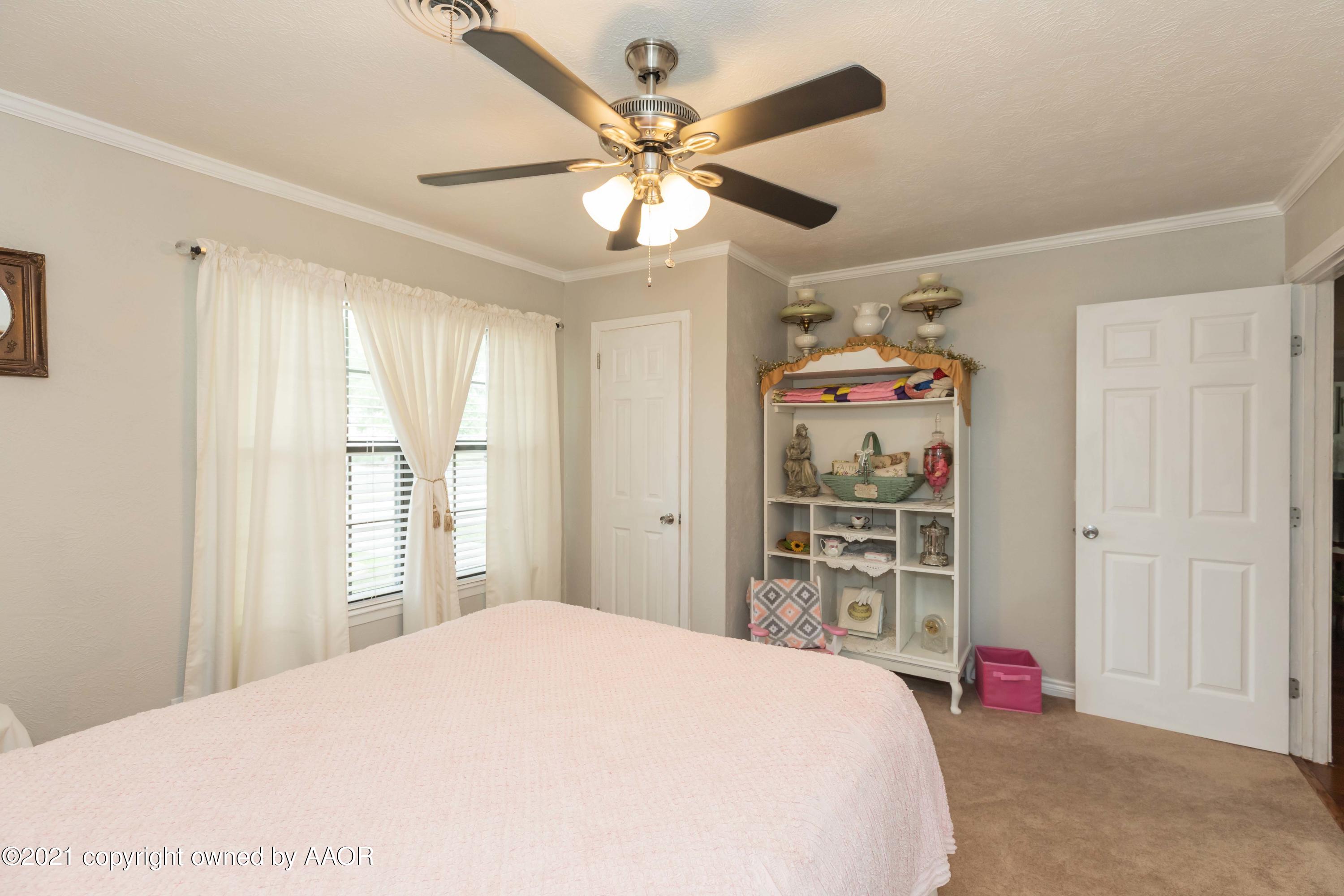 4707 Journey Street Amarillo, TX 79110 - Photo 31 of 65 a bedroom with a bed and a chandelier