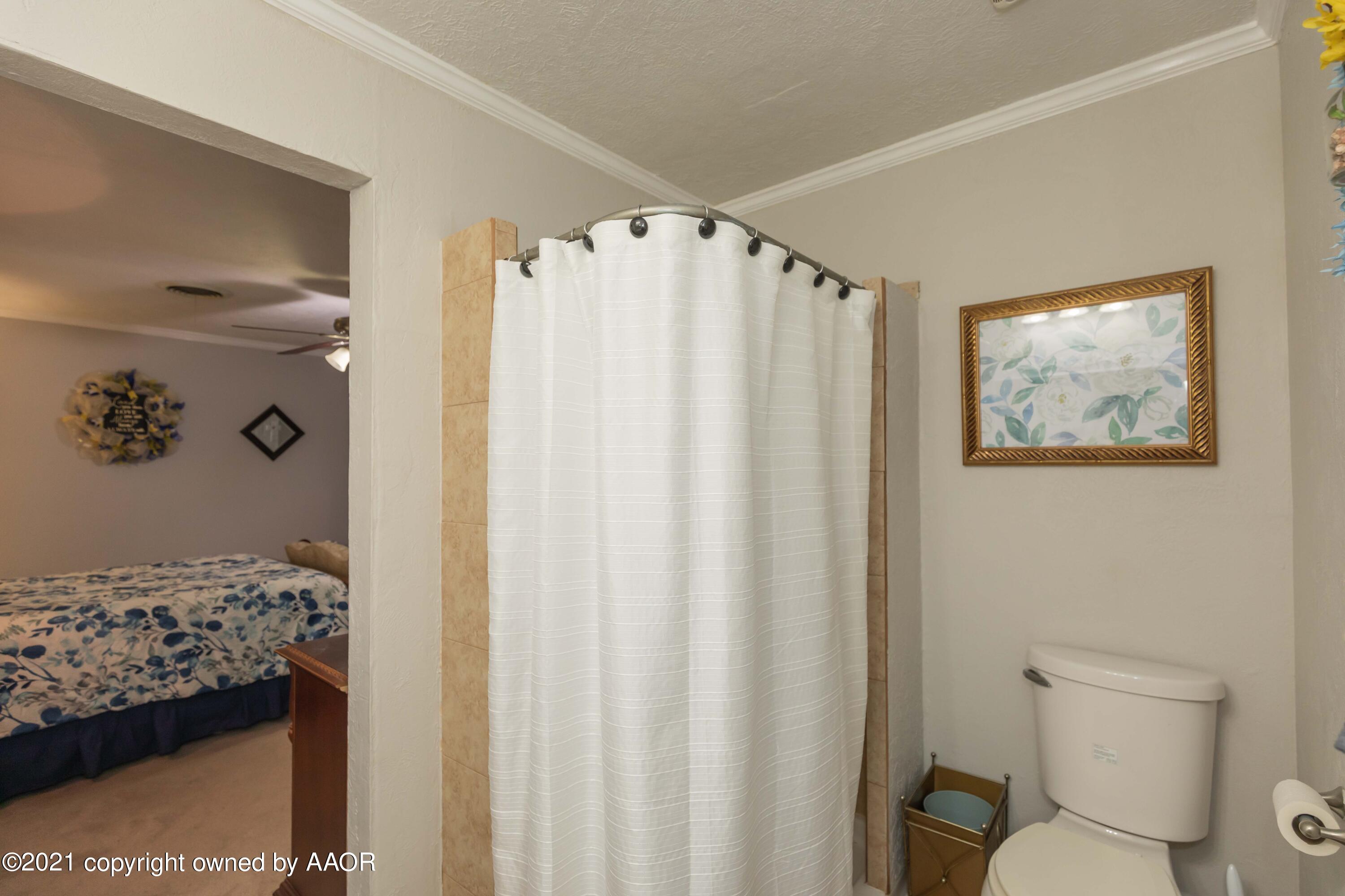 4707 Journey Street Amarillo, TX 79110 - Photo 38 of 65 a bathroom with a shower curtain and a toilet