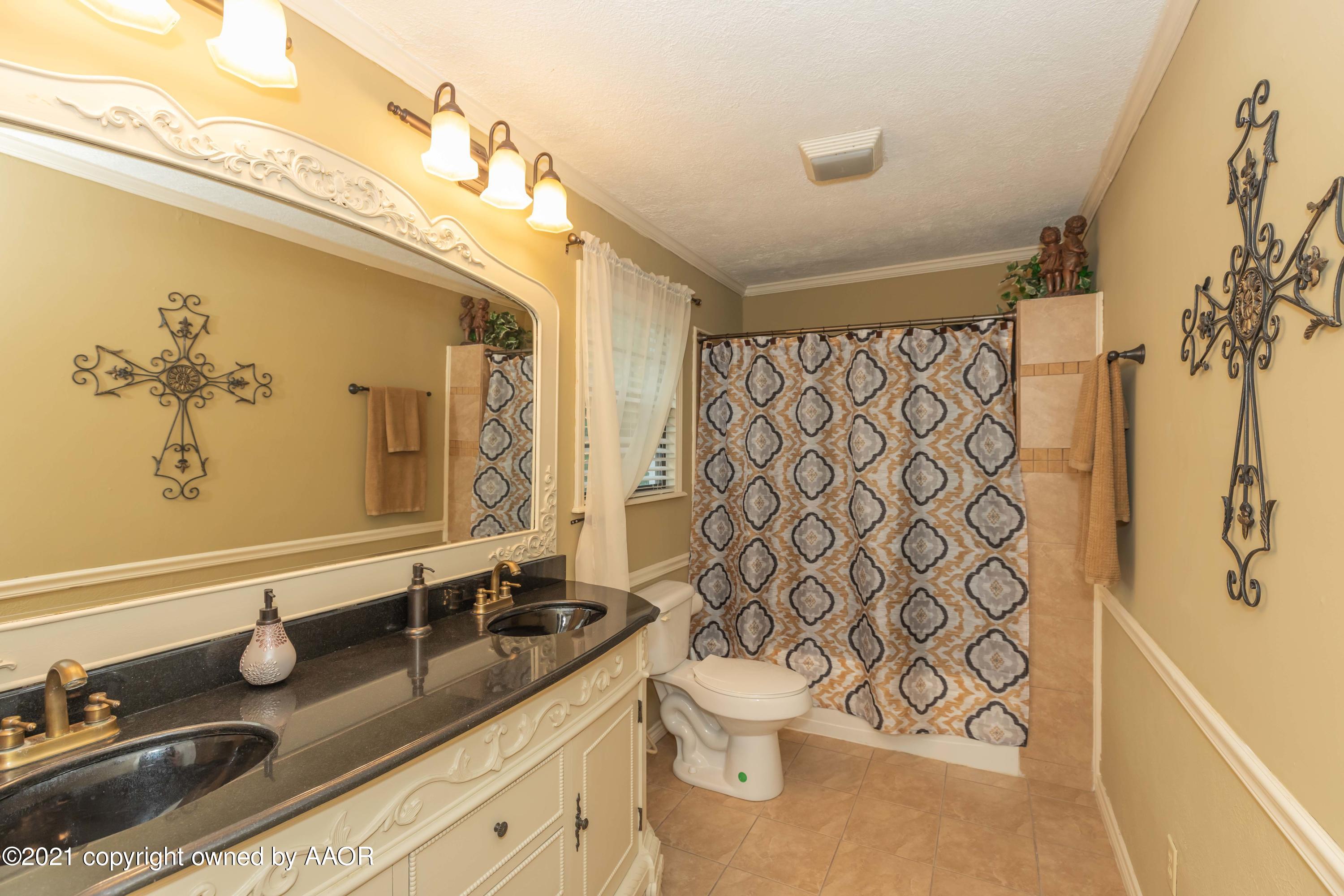 4707 Journey Street Amarillo, TX 79110 - Photo 41 of 65 a bathroom with a granite countertop sink and a mirror