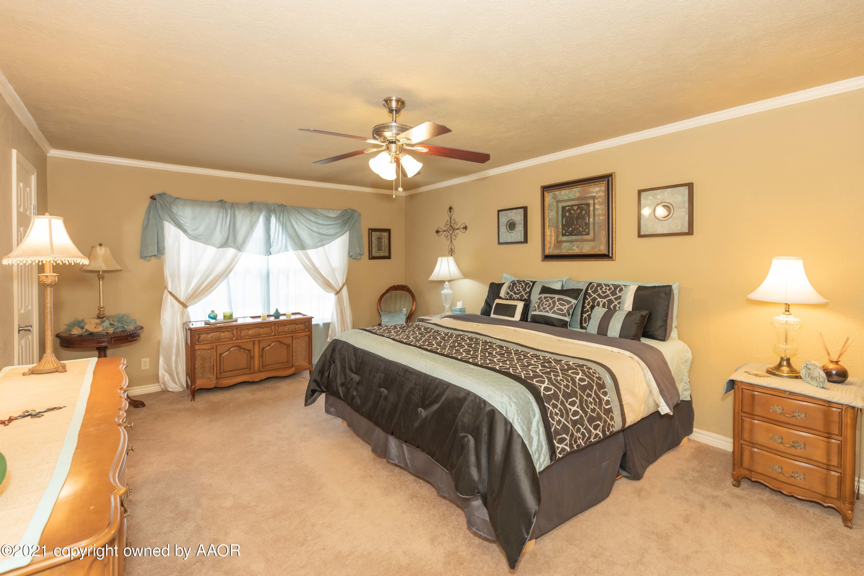 4707 Journey Street Amarillo, TX 79110 - Photo 45 of 65 a spacious bedroom with a bed and a chandelier