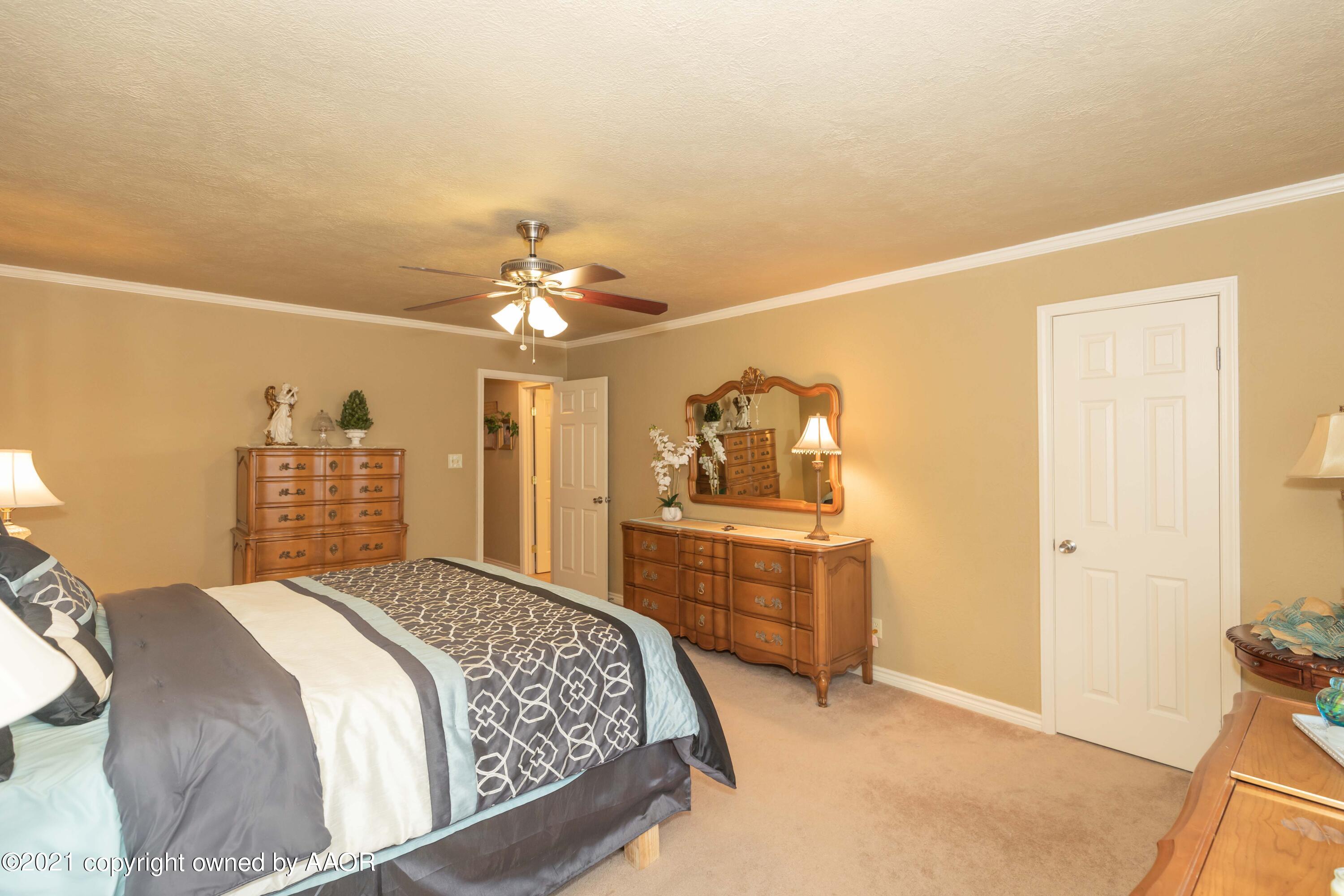 4707 Journey Street Amarillo, TX 79110 - Photo 46 of 65 a bedroom with a bed and a chandelier