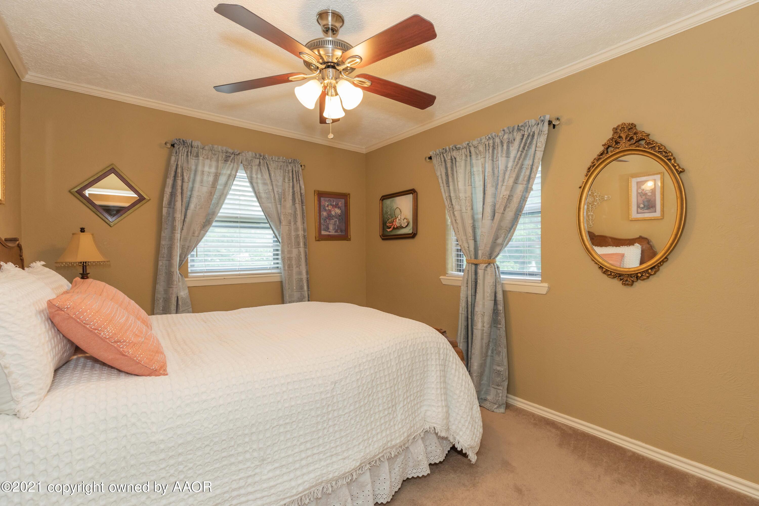 4707 Journey Street Amarillo, TX 79110 - Photo 49 of 65 a bedroom with a bed and a chandelier