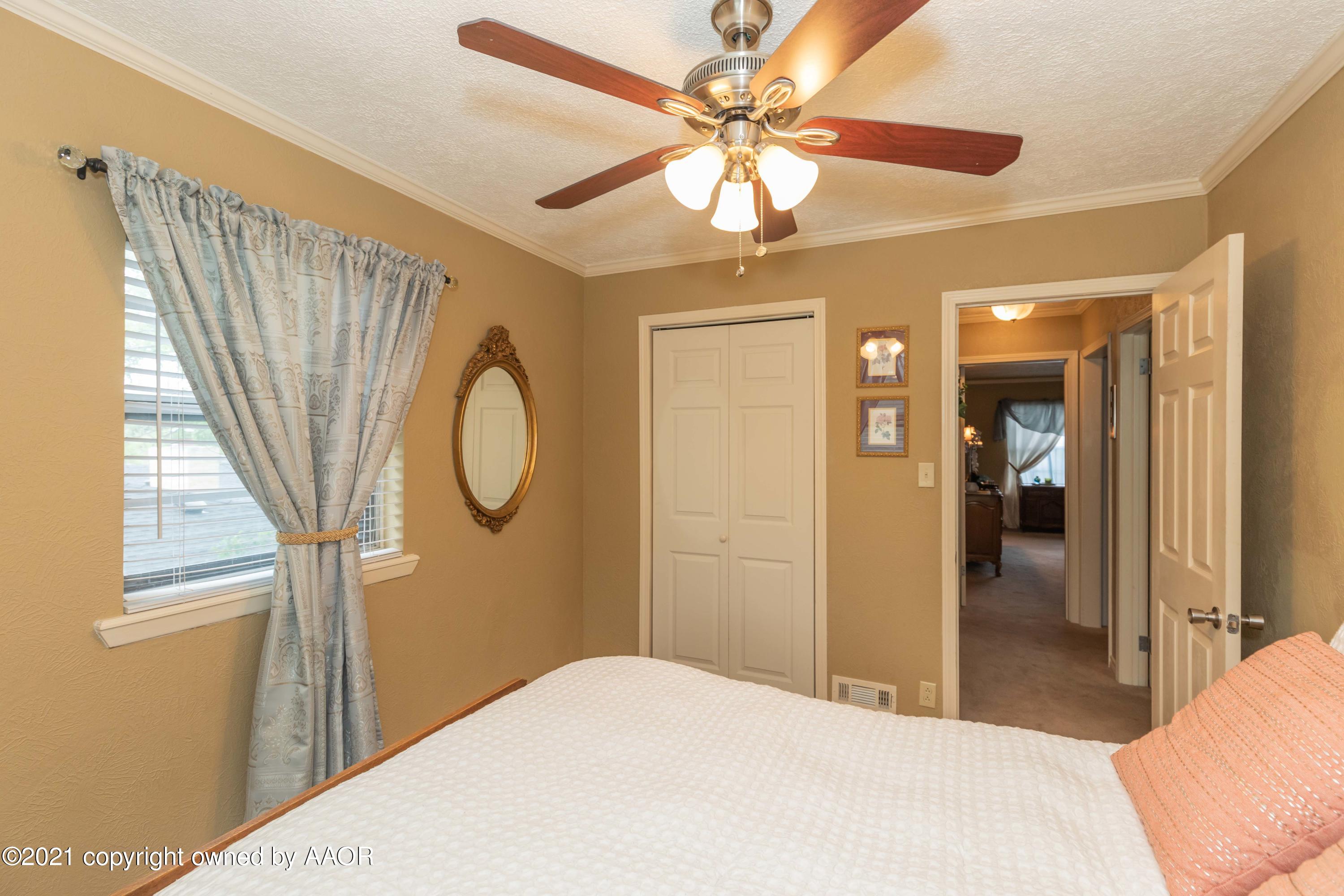 4707 Journey Street Amarillo, TX 79110 - Photo 51 of 65 a bedroom with a bed and a chandelier