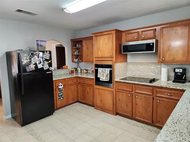 a kitchen with stainless steel appliances granite countertop a refrigerator stove and sink