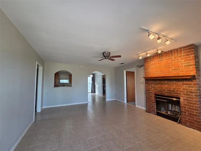 a view of a livingroom with a fireplace and a ceiling fan