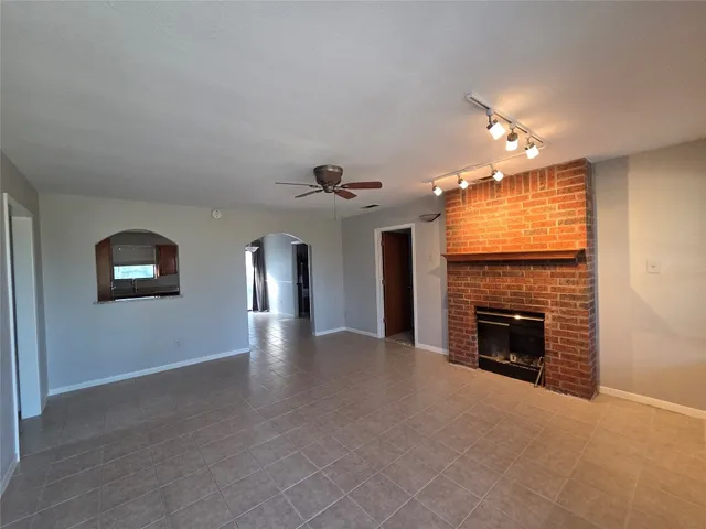 an empty room with windows and fireplace