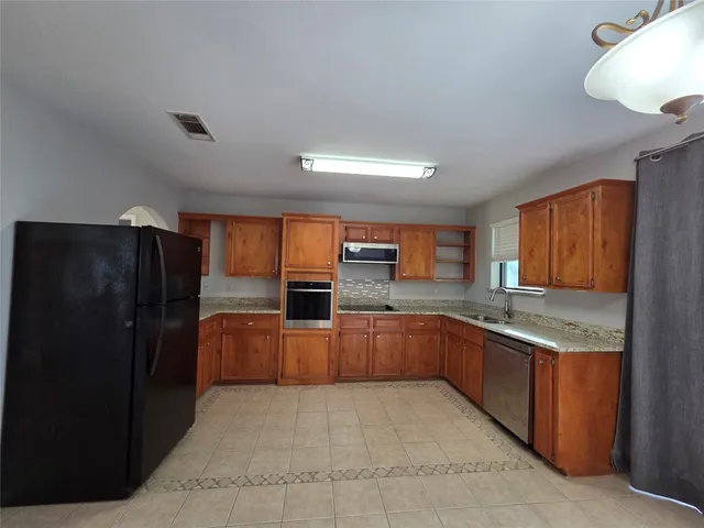 a kitchen with stainless steel appliances granite countertop a refrigerator and a sink