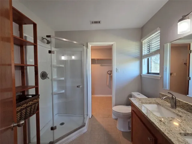 a bathroom with a granite countertop sink toilet and shower