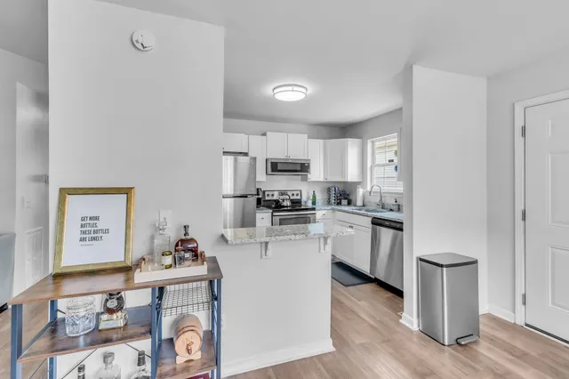 a kitchen with cabinets and wooden floor
