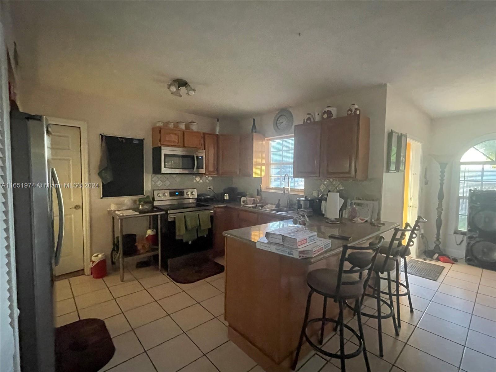 29361 Maine Road Homestead, FL 33033 - Photo 4 of 12 a kitchen with a refrigerator and a stove top oven