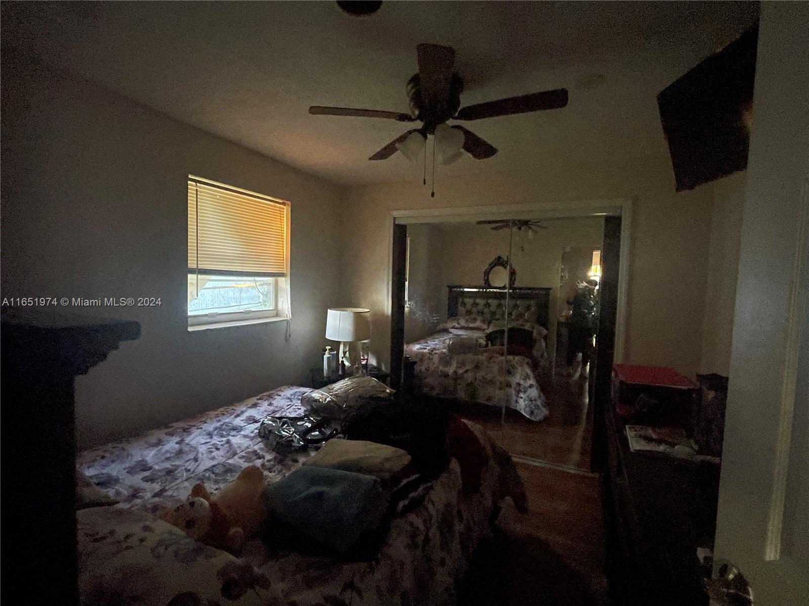 29361 Maine Road Homestead, FL 33033 - Photo 10 of 12 a bedroom with a bed and a chandelier