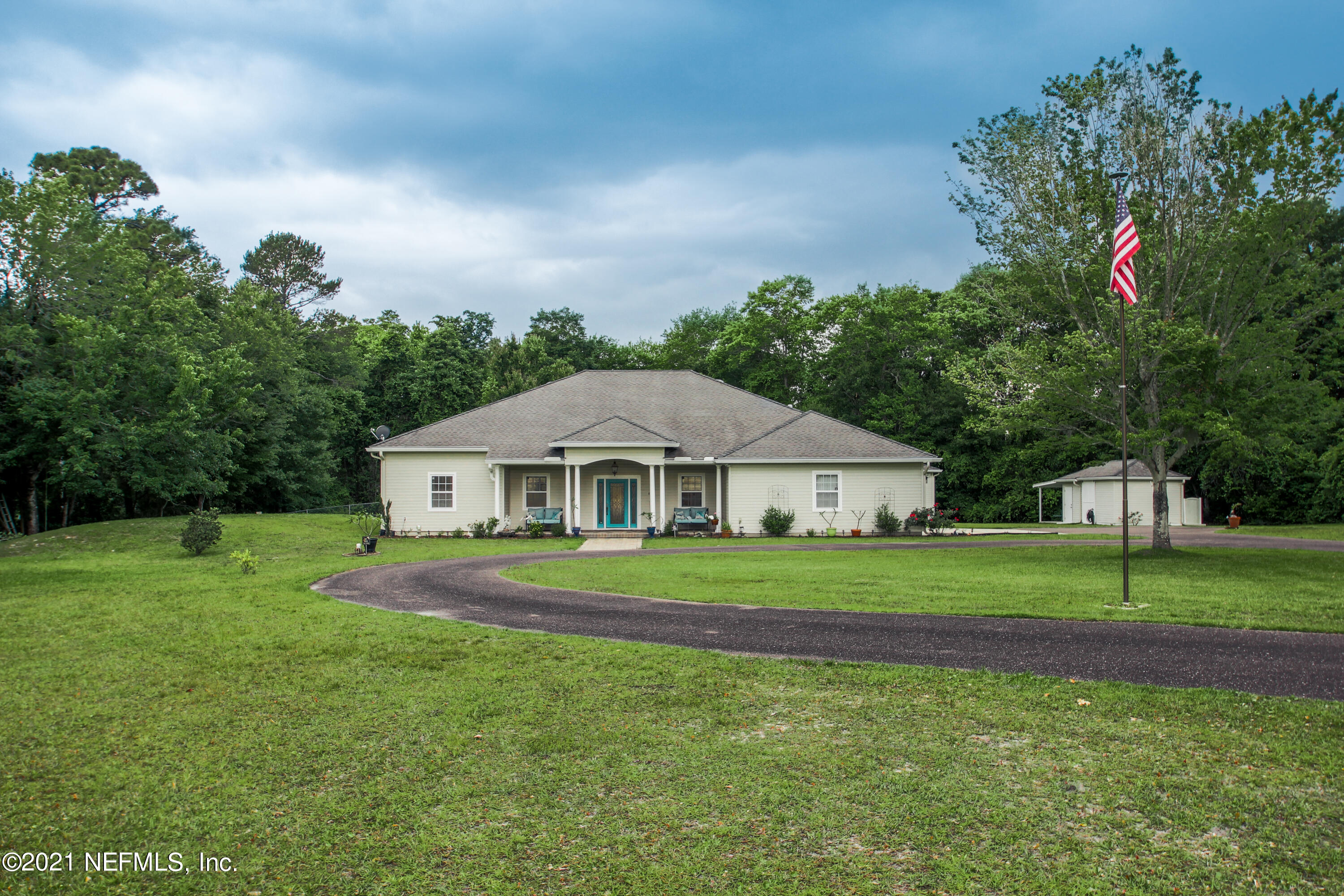 1386 Long Bay Road Middleburg, FL 32068 - Photo 3 of 40 a front view of a house with a yard and trees