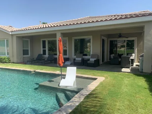 a view of a house with swimming pool patio and a yard