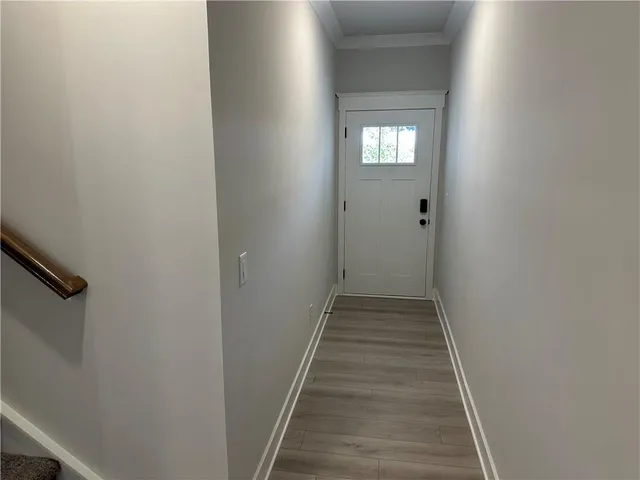 a view of a hallway with wooden floor and windows