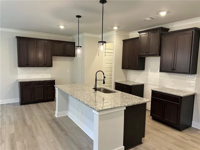 a kitchen with granite countertop wooden cabinets and stainless steel appliances