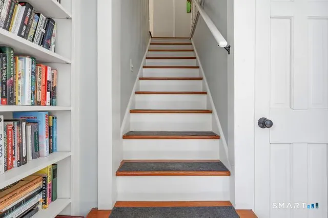 a view of a hallway with wooden floor and staircase