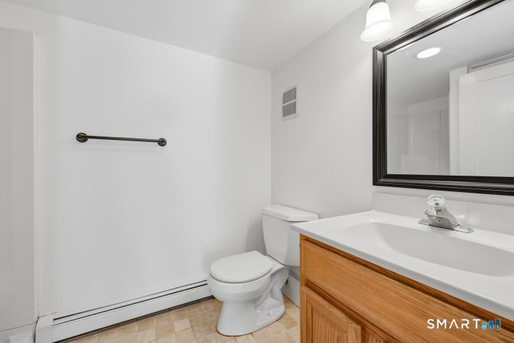 402 Boston Street Guilford, CT 06437 - Photo 33 of 40 Ground level room as part of 3-room living area that has many potential uses.....has been utilized as a the third full bathroom that a family member used as part of an apartment