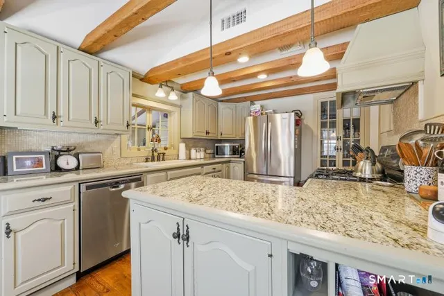 a kitchen with stainless steel appliances granite countertop a sink and cabinets