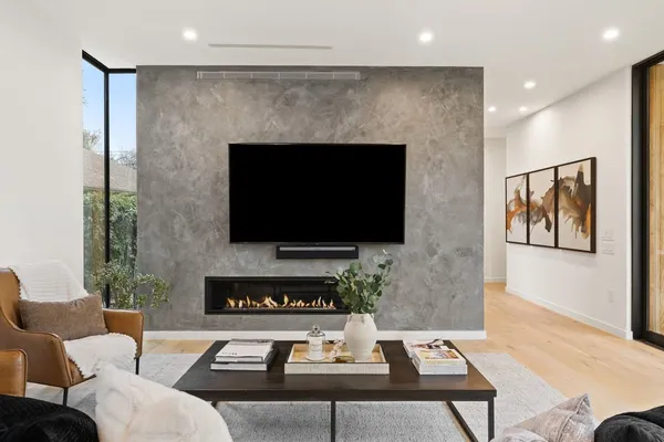 a living room with furniture a flat screen tv and a fireplace