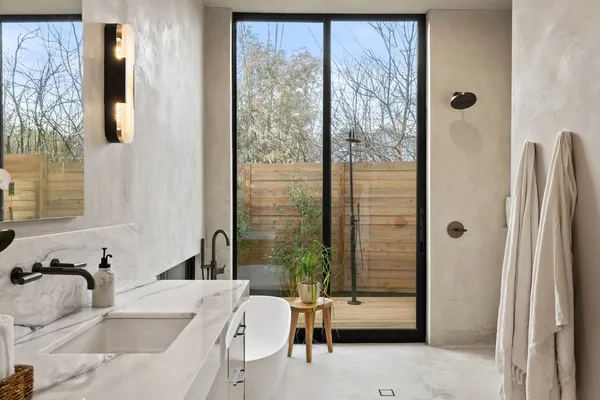 a bathroom with a tub sink and mirror
