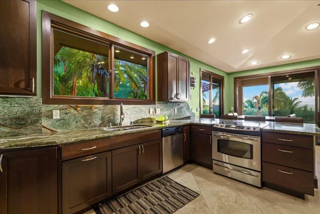 a kitchen with stainless steel appliances granite countertop sink stove and cabinets