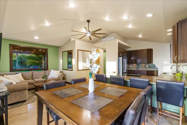 a living room with furniture kitchen view and a large window