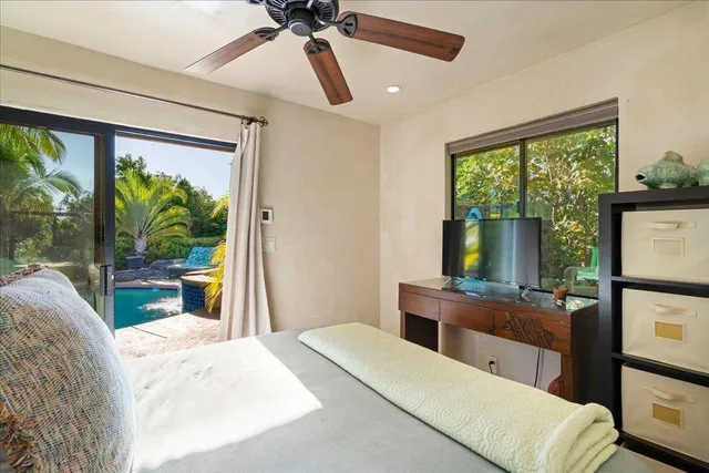 a bedroom with a bed and large windows