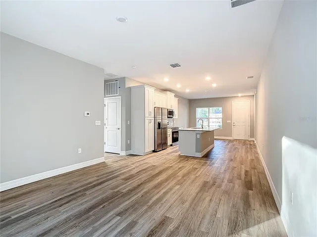a view of a kitchen with a sink and wooden floor