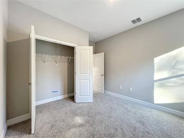 an empty room with closet and a bathroom