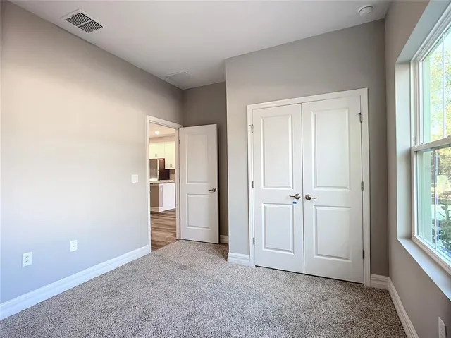 an empty room with windows and closet