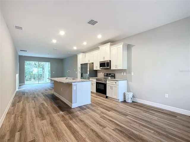 a large kitchen with stainless steel appliances granite countertop a stove and a sink