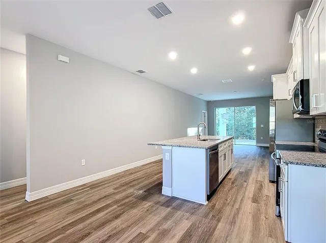 a kitchen with granite countertop a sink and a stove top oven