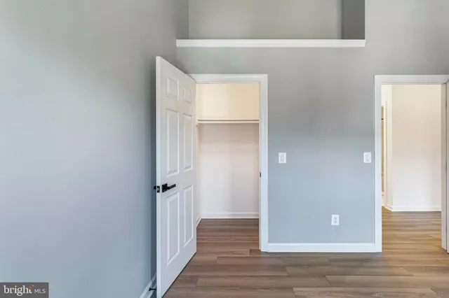 a view of a hallway view with wooden floor and living room