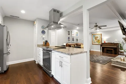 a kitchen with a stove and wooden floor