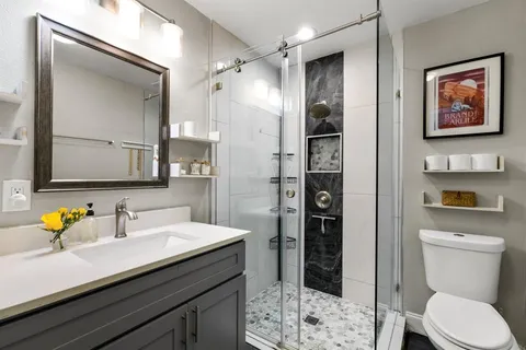 a bathroom with a sink a toilet and shower