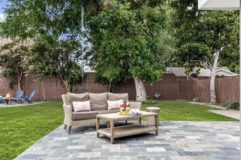 a backyard of a house with fountain table and chairs