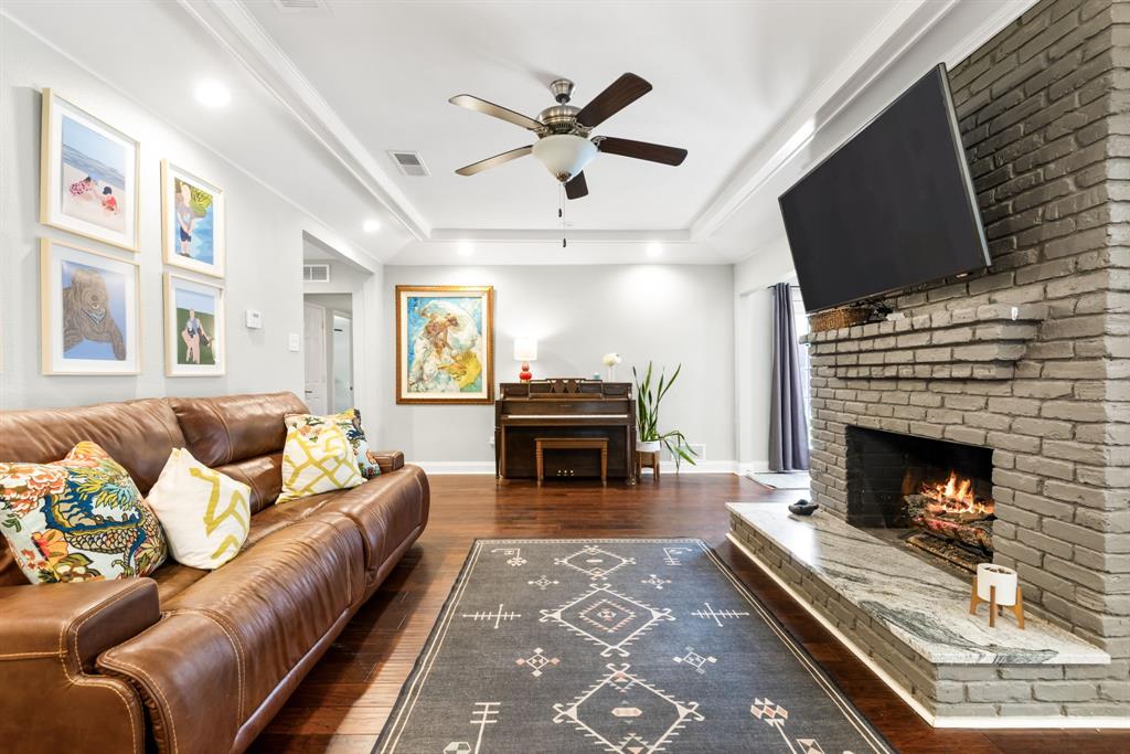 3236 Merrell Road Dallas, TX 75229 - Photo 4 of 24 a living room with furniture a fireplace and a flat screen tv