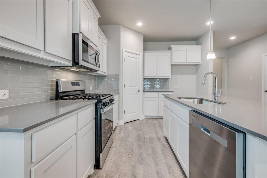 254 Lunayena Road Rhome, TX 76078 - Photo 2 of 8 a kitchen with stainless steel appliances granite countertop a sink a stove and cabinets