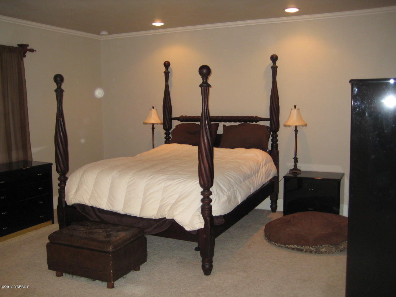 6591 West Wapato Road Wapato, WA 98951 - Photo 12 of 46 a bed sitting in a bedroom next to a window