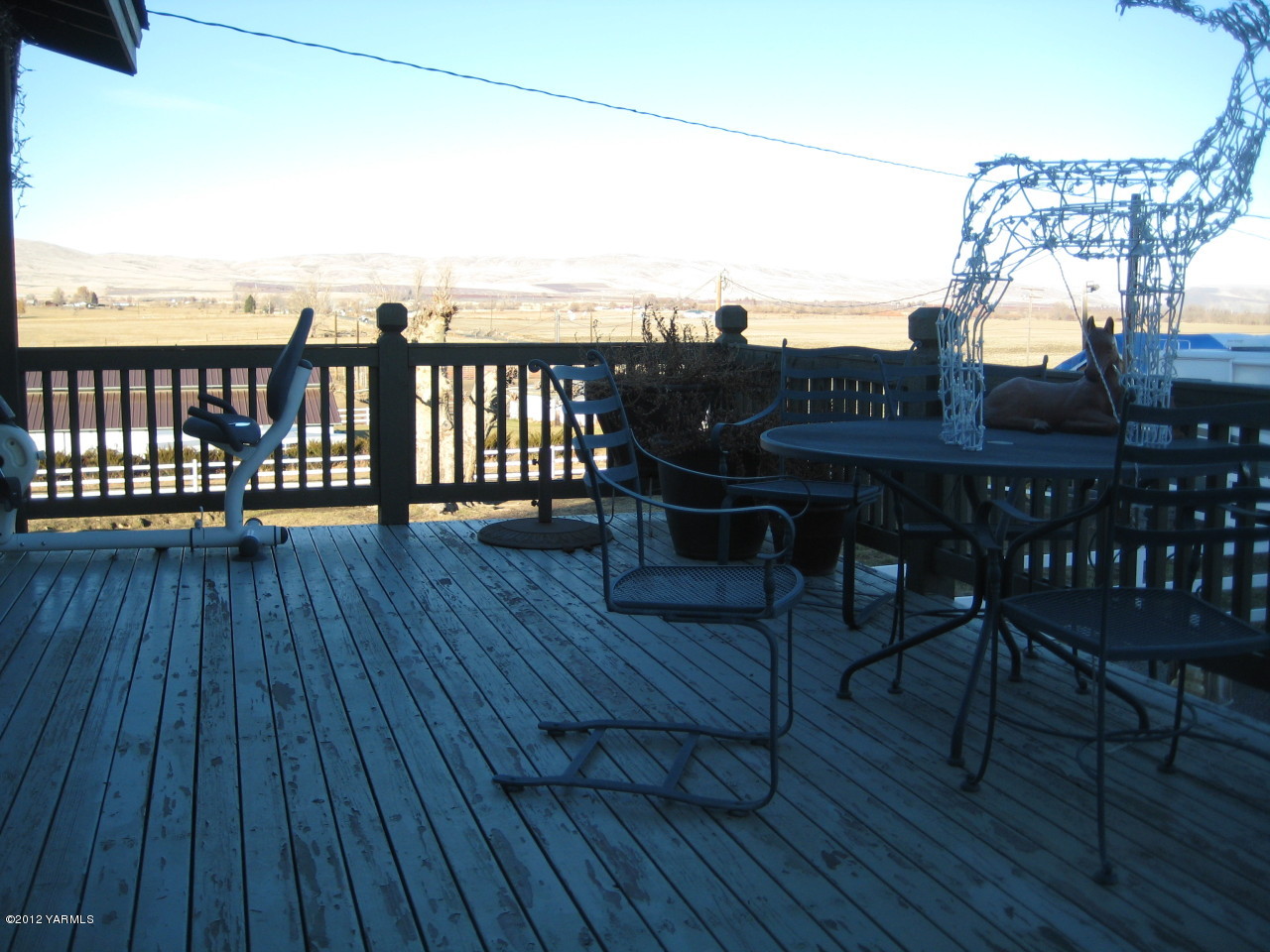 6591 West Wapato Road Wapato, WA 98951 - Photo 25 of 46 a view of a roof deck with table and chairs a barbeque with wooden floor and fence