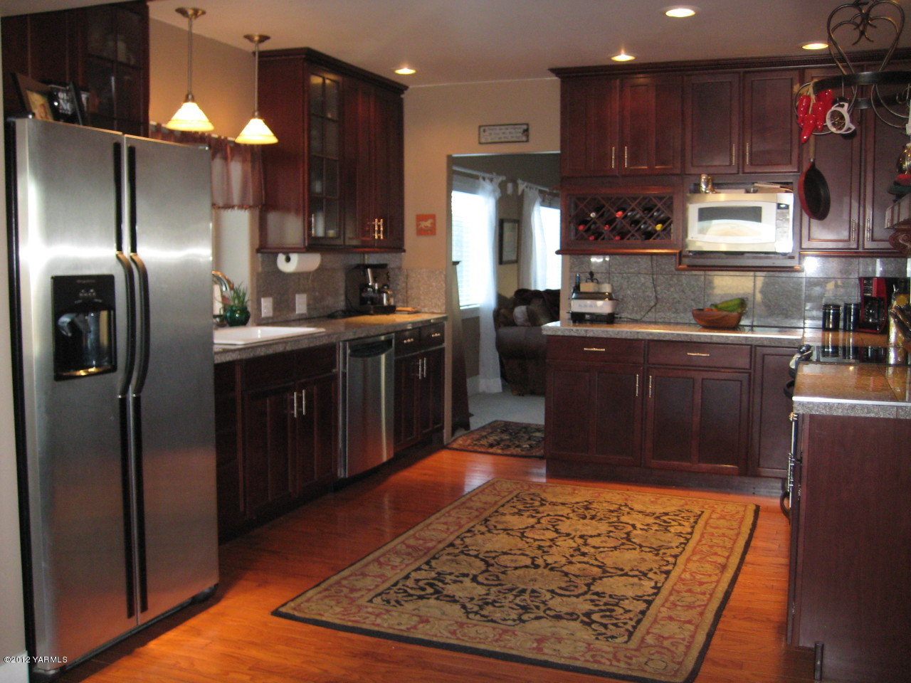 6591 West Wapato Road Wapato, WA 98951 - Photo 4 of 46 a kitchen with stainless steel appliances granite countertop a refrigerator stove top oven and cabinets