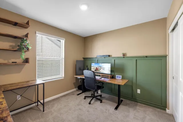 a view of a workspace with furniture and a window