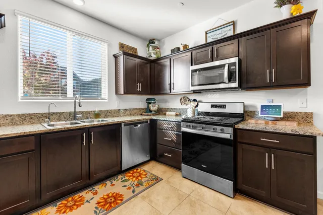 a kitchen with stainless steel appliances granite countertop a sink and a stove
