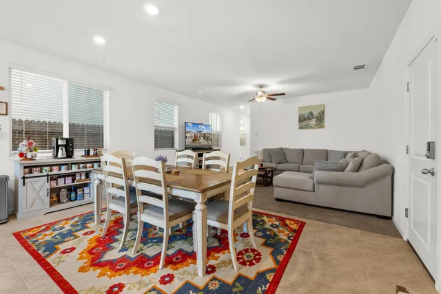 a living room with furniture a rug and kitchen view