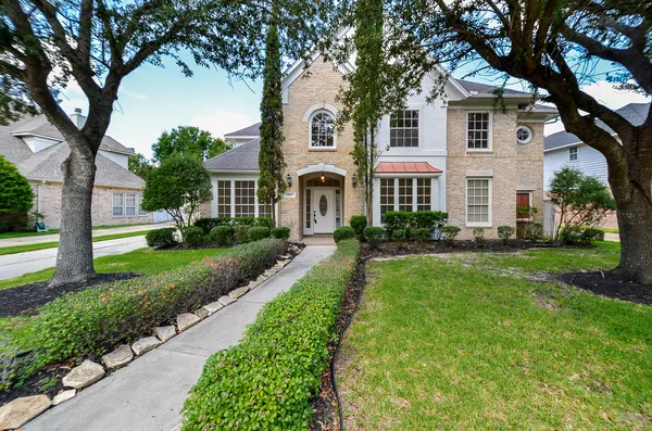 a front view of a house with a yard and trees
